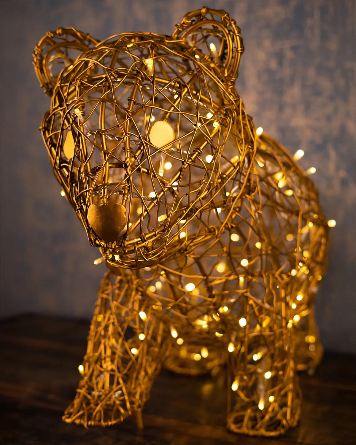 Leuchtobjekt in Bärenform aus goldener Aluminiumstruktur – detailreiche Drahtskulptur mit warmweißer LED-Beleuchtung, inszeniert im Innenraum.